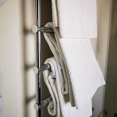 White terry towels are drying on a radiator.