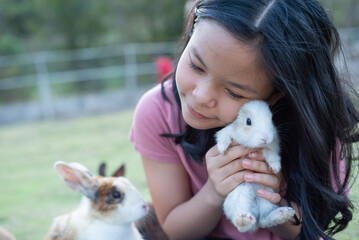 teenage girl with the rabbit. happy little girl holding cute fluffy bunny. friendship with easter bunny. spring photo with beautiful young girl with her bunny. girl is holding a cute little rabbit.