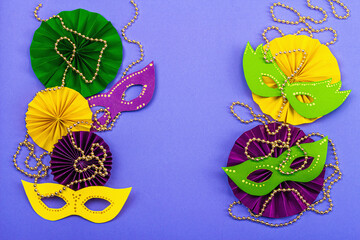 Festive Mardi Gras masquerade violet background. Fat Tuesday carnival, masks, beads, traditional...