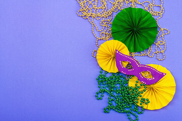 Festive Mardi Gras masquerade violet background. Fat Tuesday carnival, masks, beads, traditional...