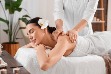 Obraz na płótnie Canvas Young woman enjoying professional massage in spa salon
