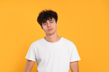 Fototapeta premium Portrait of handsome young man on orange background