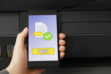 Woman using printer management application on smartphone, closeup and space for text. Image on...