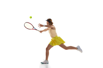 Studio shot of professional young female tennis player in sports uniform training with tennis racket isoltaed over white background. Concept of skills, sport, fashion, ad