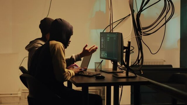 Spy using hacking concept and hacktivism for digital espionage, stealing important government information. Male hacker working with trojan virus to hack firewall, doing cyberattack.