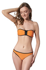 Fototapeta premium A lady is wearing a two-piece orange swimsuit with black border composed of low-rise bikinis and a bandeau bra with zipper. The girl in the swimwear is posing on a white background.