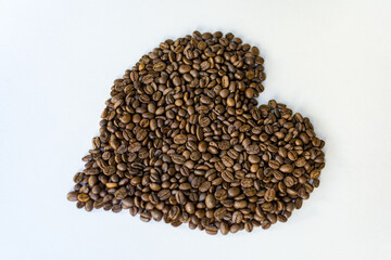 Hearth made of coffee beans origin full arabica on a white cafeteria table - 568738406