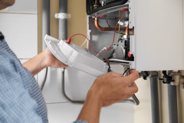 Man opening top of gas boiler indoors, closeup - obrazy, fototapety, plakaty