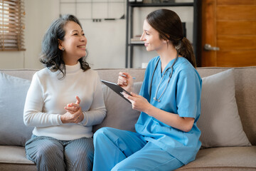 Female doctor consulting senior old patient filling form at consultation, talking to senior old patient filling signing medical paper at appointment visit in clinic.