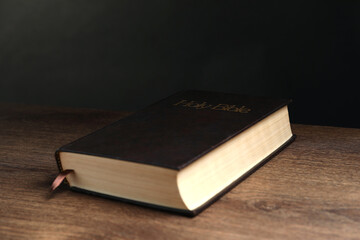 Hardcover Bible on wooden table. Religious book