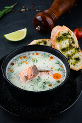 Finnish style fish soup with salmon, cream, potatoes, dill and bread with sauce and spices.