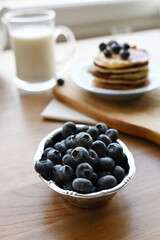 delicious homemade pancakes with blueberries on wooden background