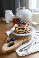 delicious homemade pancakes with blueberries on wooden background