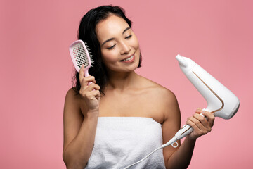Portrait of nice-looking cute lady drying healthy hair isolated on pink studio background