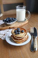 delicious homemade pancakes with blueberries on wooden background