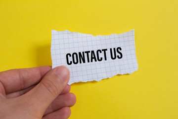 Contact Us word written on torn paper.