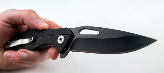 closeup hand holding a tanto combat knife isolated on white