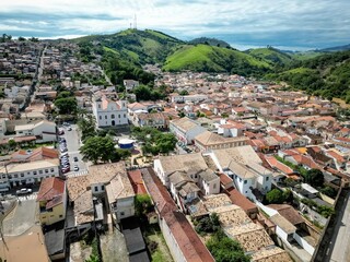 Rio cheio visto de cima casas alagadas com fundo para paisagem.
