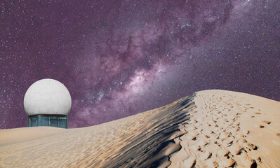 Radar dome tower behind the dunes and starry sky with the milky way.