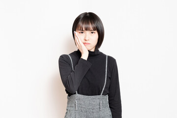 歯が痛くて困っている若い女性