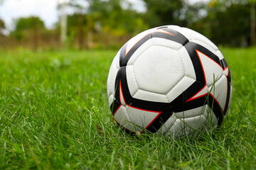 Fototapeta na wymiar New soccer ball on fresh green grass outdoors