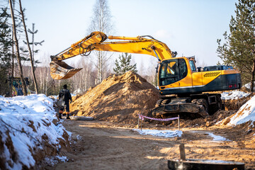 the process of loosening frozen winter soil with an excavator bucket