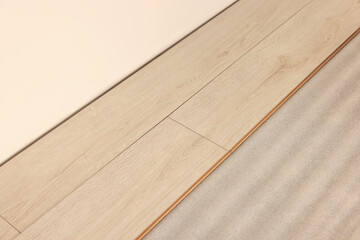 Parquet planks on floor near wall in room prepared for renovation