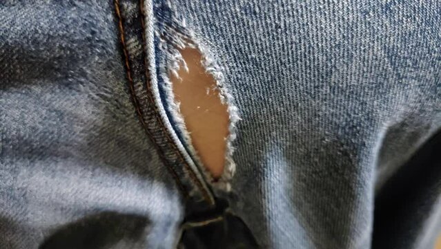 Rubbing through hole in jeans pants