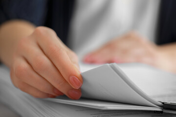 Woman reading documents at table in office, closeup. Space for text
