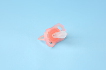 One new baby pacifier on light blue background