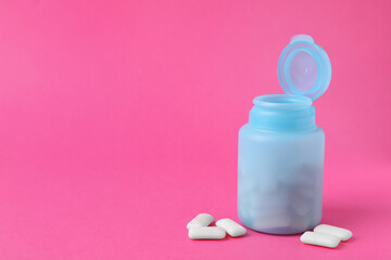 Jar with chewing gums on pink background. Space for text