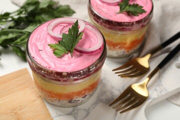 Herring under fur coat salad served on white table, closeup. Traditional Russian dish