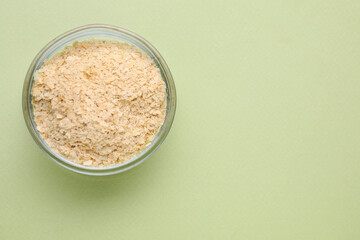 Beer yeast flakes on light green background, top view. Space for text