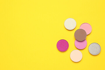 Beautiful eye shadow refill pans on yellow background, flat lay. Space for text