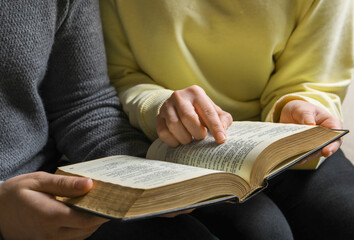 Couple sitting and reading holy Bible, closeup