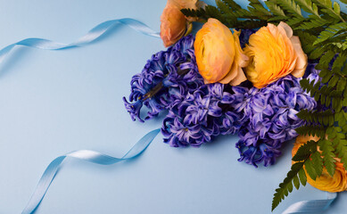 Composition of Purple Hyacinth and Yellow Buttercups on Light Blue Background. Holiday banner, copy...