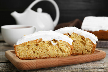 Pieces of homemade yogurt cake with cream on wooden table, closeup