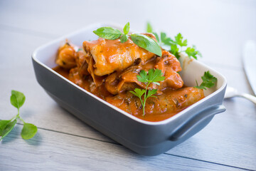 Traditional stuffed cabbage with minced meat and rice, served in a tomato sauce.