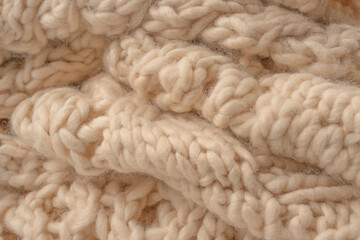 A fragment of beige knitted fabric, knitted from white sheep wool.