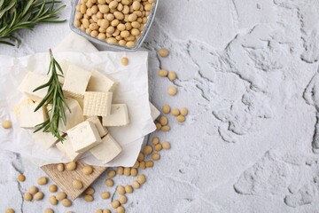 Delicious tofu cheese, rosemary and soybeans on light gray textured table, flat lay. Space for text