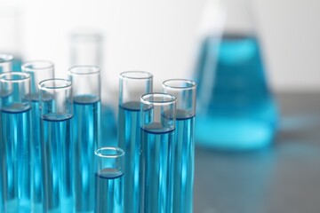 Test tubes with light blue liquid in laboratory, closeup