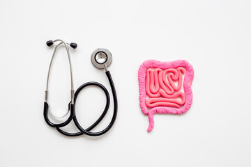 Digestive colon system health concept. Intestines shape made of plasticine with stethoscope