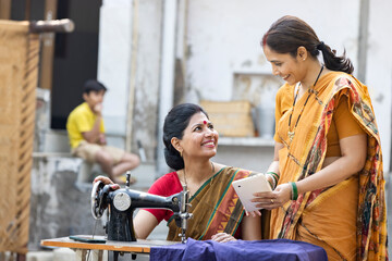 Indian woman using sewing machine at home.