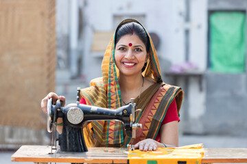 Indian rural woman using sewing machine at home