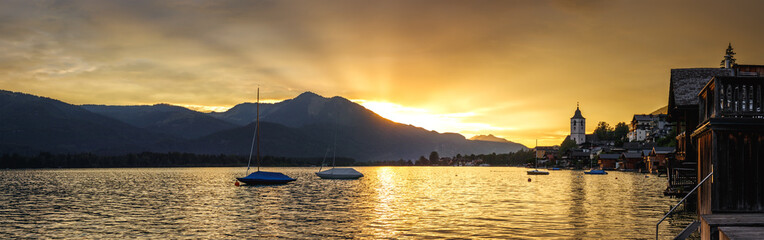 Panoramic landscape with sunset over Wolfgangsee lake at St. Wolfgang, Upper Austria. Golden hour in Alps mountain