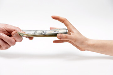 Man's hand offers dollar bribe, and a woman greedily reaches for money. Close-up. Concept of bribery and corruption