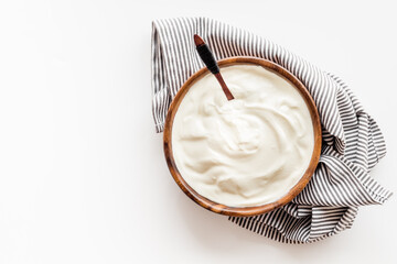 White sauce sour cream or yogurt in wooden bowl, top view