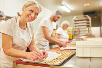 Frau als Bäcker Lehrling beim Backen von Vanillekipferl
