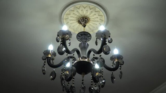 The chandelier swings from buildings shaking during an earthquake. Middle shot
