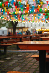 Easter market with colorful flags bunting banner and lights decoration on rainy day. Festive happy birthday celebration background.